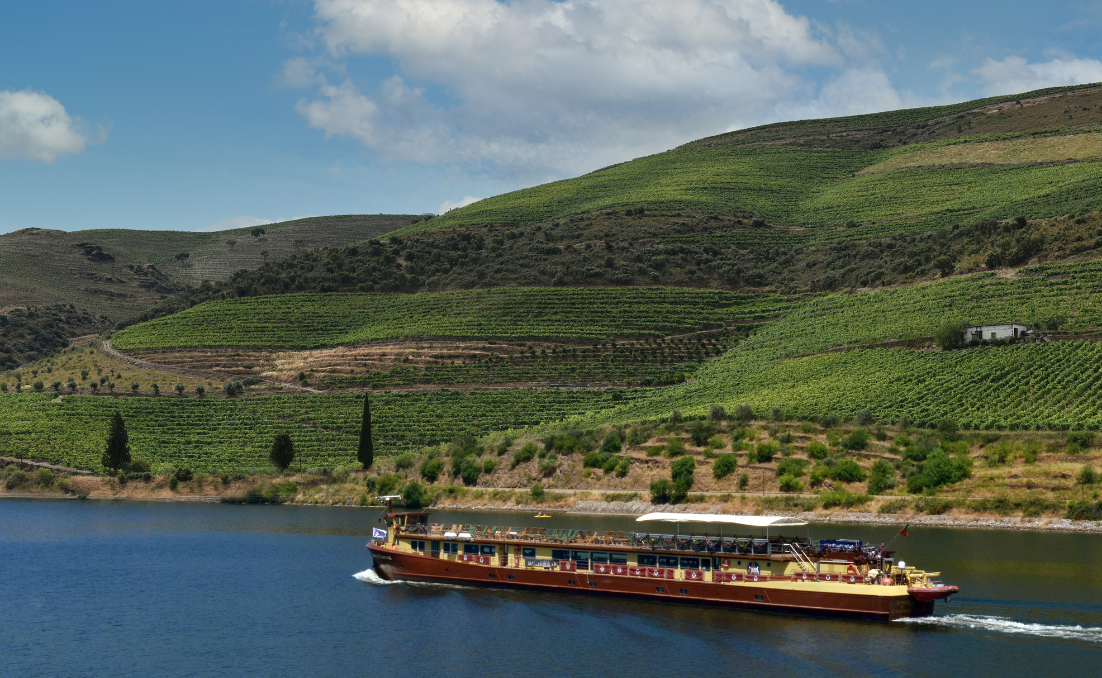 Navio de pequeno porte da empresa DouroAzul, Spirit of Chartwell, navegando o rio Douro em um dia ensolarado